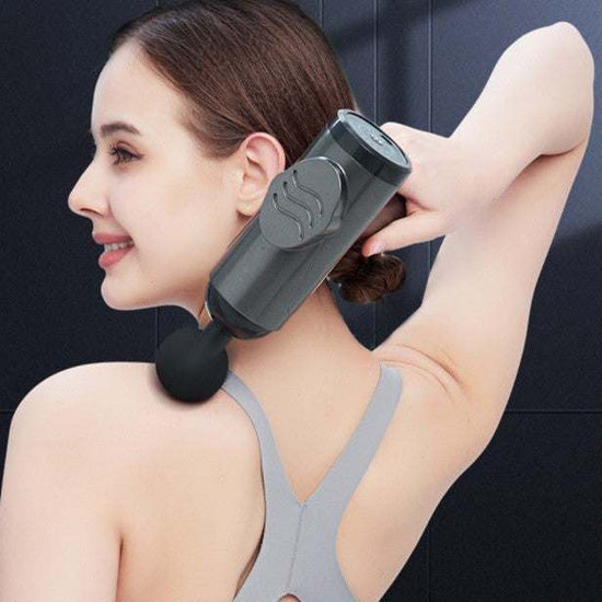 Woman using dark gray massage gun for muscle relaxation on shoulder with multi-gear adjustment and LED screen